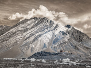 A mountain with snow on it and clouds in the sky.