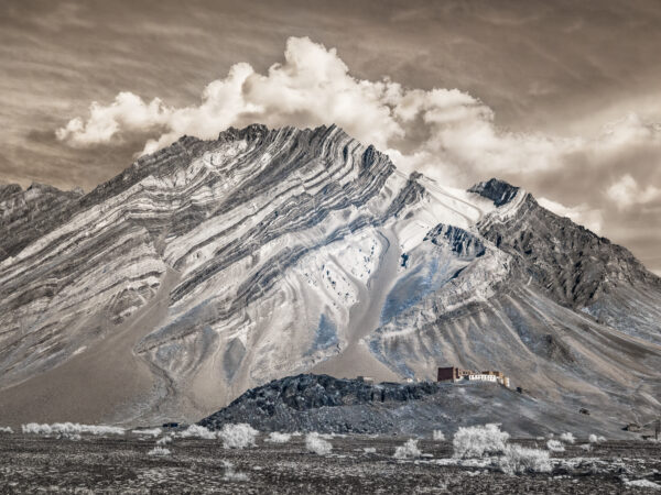 A mountain with snow on it and clouds in the sky.
