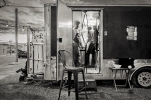 A black and white photo of two men in a trailer.