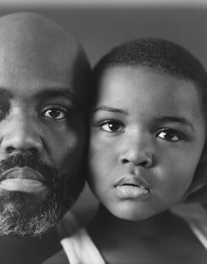 A man and boy are looking at the camera.
