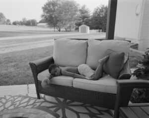 A child laying on the back of a couch.
