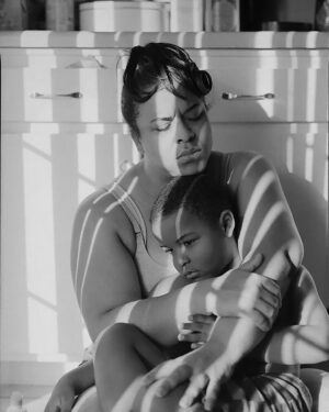 A woman holding her child in the arms of another person.