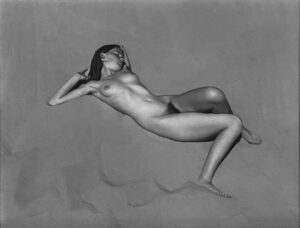 A naked woman is laying on the ground