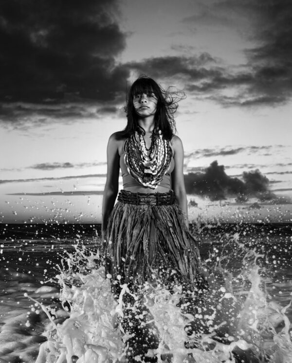 A woman standing in the water at the beach.