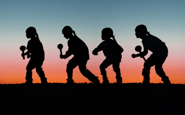 A silhouette of a person swinging a baseball bat.