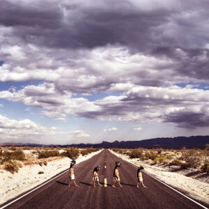 A group of people standing on the side of a road.