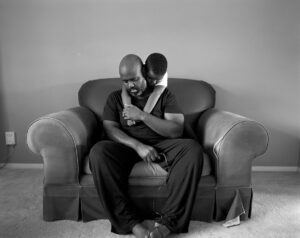 A man sitting on the arm of another person.