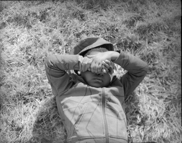 A man laying in the grass wearing a hat.
