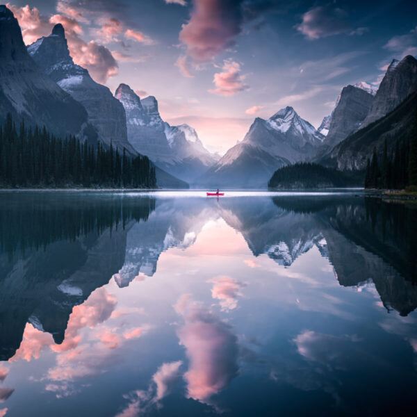 A lake with mountains in the background and clouds