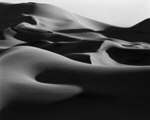 A black and white photo of some sand dunes