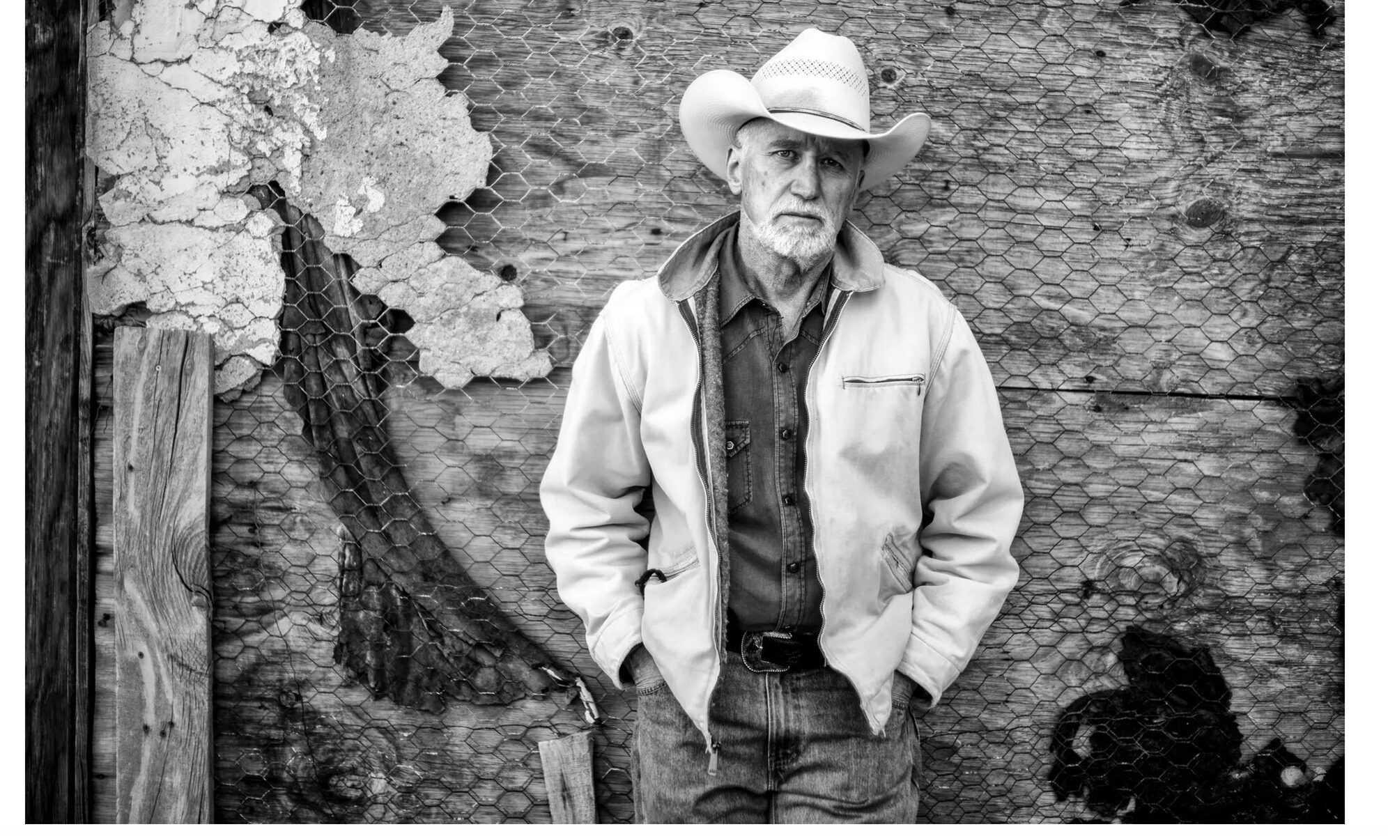 Man in cowboy hat against textured background.