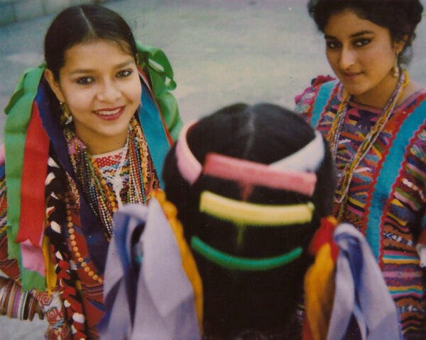 Two girls in colorful clothing posing for a picture.