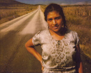 A woman standing in front of an empty road.