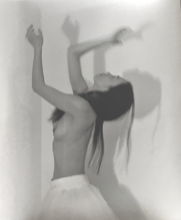A woman in white shorts and a bra is dancing.