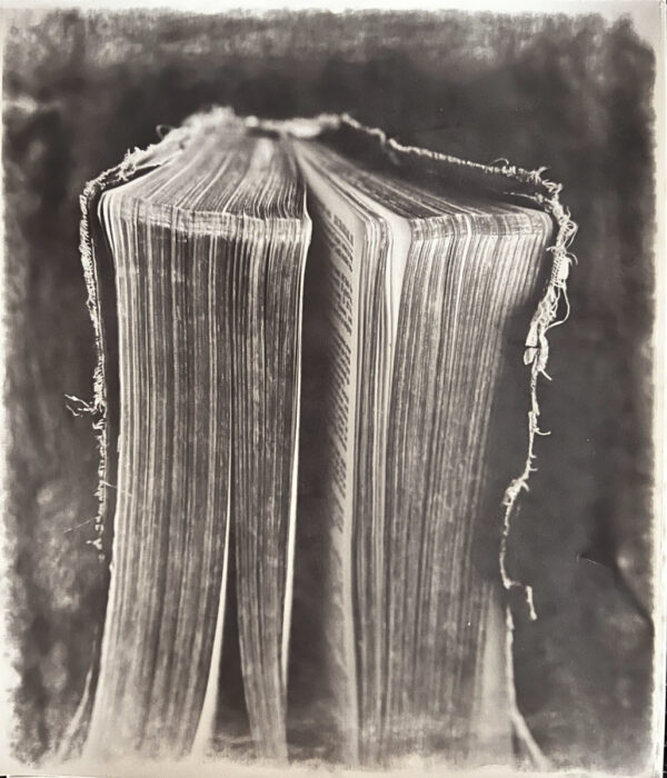 A book is folded in half and has been photographed.