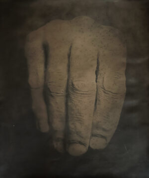 A hand with its fingers pressed against the wall.