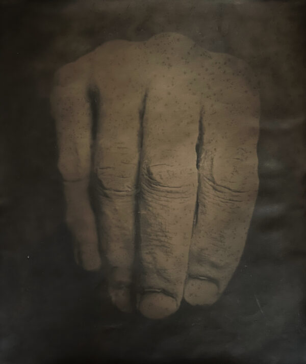 A hand with its fingers pressed against the wall.