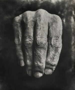 A hand with wrinkled skin is shown in this black and white photo.