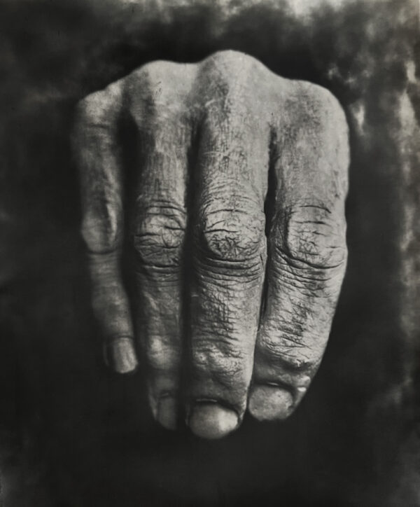 A hand with wrinkled skin is shown in this black and white photo.