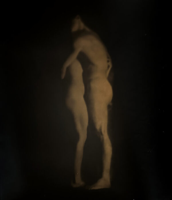 A blurry image of two people standing in the dark.