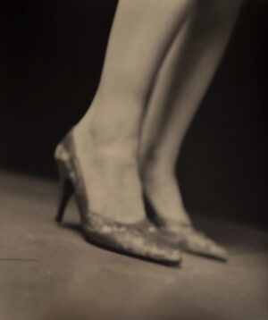 A woman 's legs and feet in high heels.
