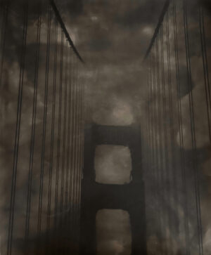 A dark picture of the golden gate bridge in fog.