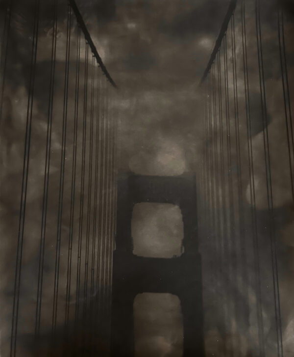 A dark picture of the golden gate bridge in fog.