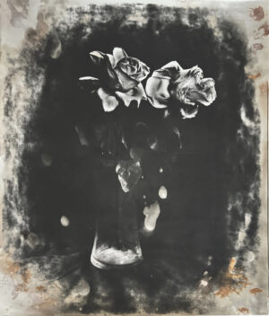 A black and white photo of flowers in a vase.