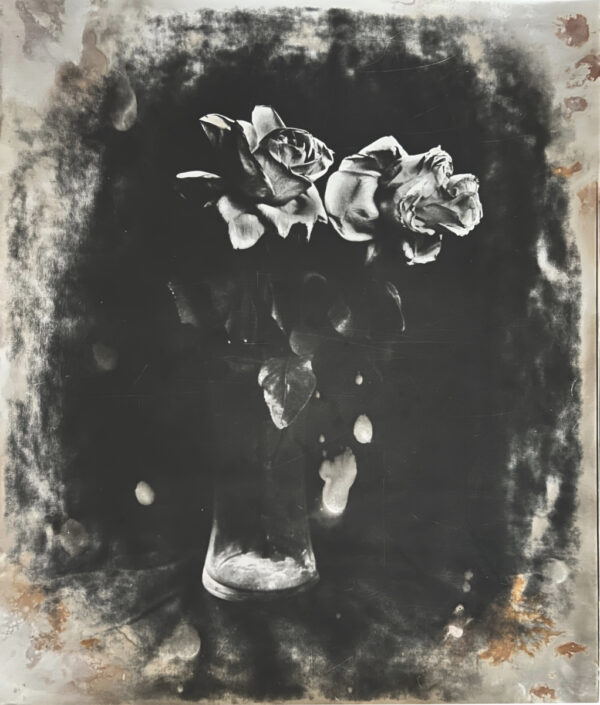 A black and white photo of flowers in a vase.