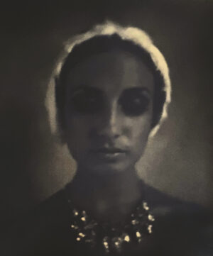 A woman with a necklace and eye patch.