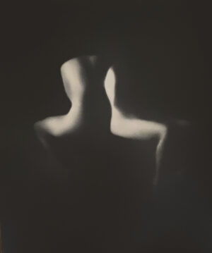 A blurry image of two people sitting in the dark.