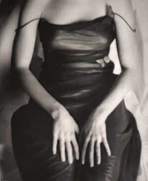 A woman in black dress sitting on top of a chair.