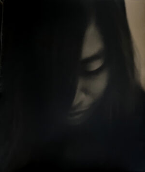 A woman with long hair and dark makeup.