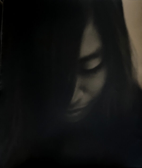 A woman with long hair and dark makeup.
