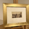 A picture of an old photo in a gold frame.