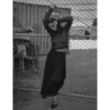A woman in black dress holding up her arms.