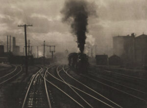 A train is going down the tracks with smoke coming out of it.