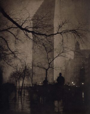 A person standing in front of tall buildings.