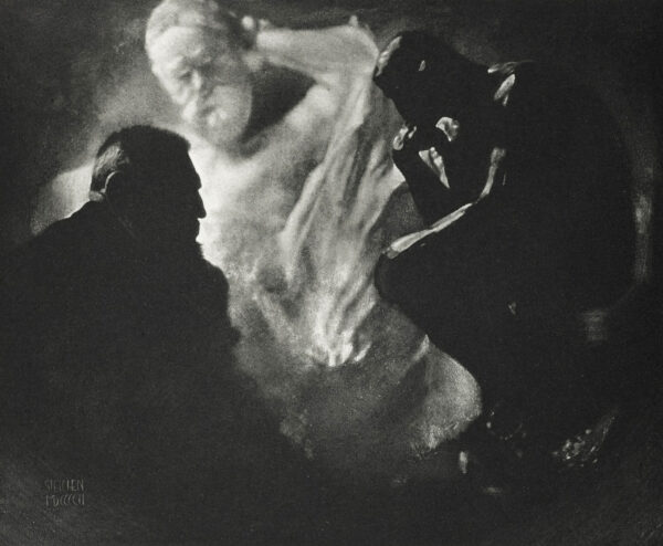 A man is standing in the dark with his arms outstretched.