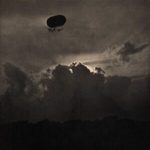 A black and white photo of a balloon in the sky.