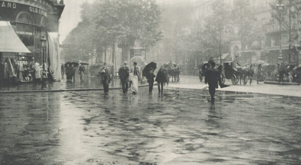 A group of people walking in the rain with umbrellas.