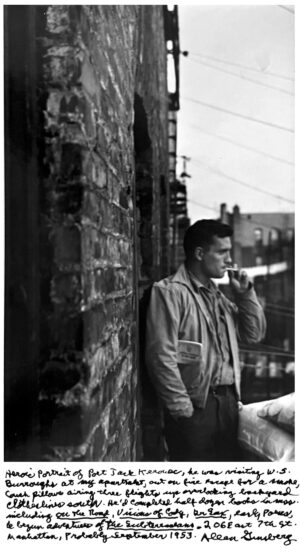 A man smoking a cigarette while leaning against a brick wall.