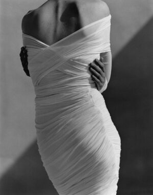 A woman in white dress standing on stairs.