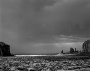 A black and white photo of the ocean with a lighthouse.