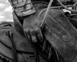 A person holding onto the back of a horse.