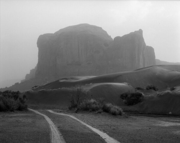 A black and white photo of a road in the middle of nowhere.