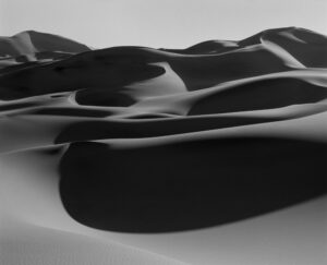 A black and white photo of sand dunes.