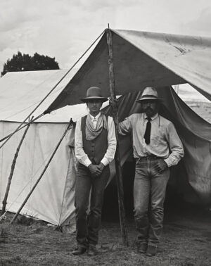 Two men standing in front of a tent.