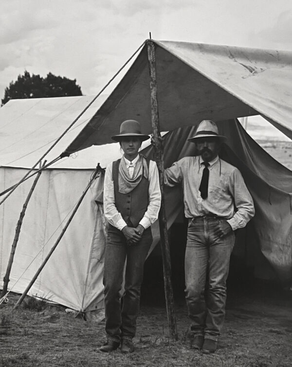 Two men standing in front of a tent.