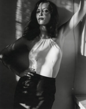 A woman in black leather skirt and white top.